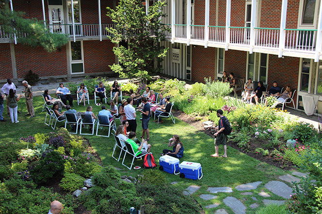 Photo of the CSWR courtyard with many people sitting enjoying lunch.