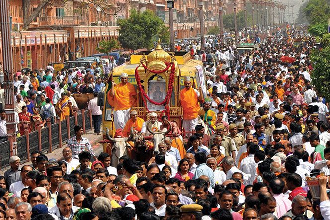 Picture of large crowd marching down the street in celebration of Mahavir Jayanti.