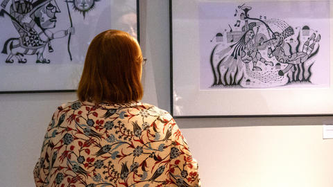 The back of a woman looking at artworks