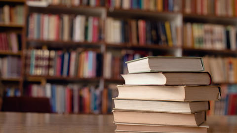 Books on a table, book shelves in the background