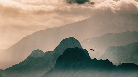 Mountain ranges one behind the other, clouds and soft light