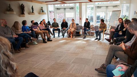 photo from workshop, attendees sitting in a large circle