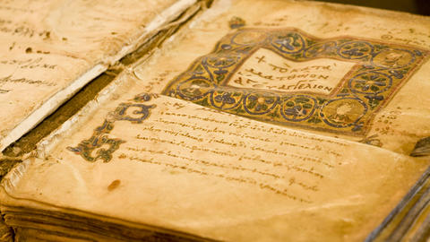 Ancient codex laying open on wooden table