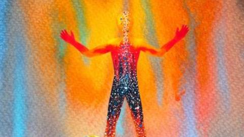watercolor image of human with arms outspread with colors all around and through image