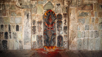 Photo of stone wall with center carving of Goddess