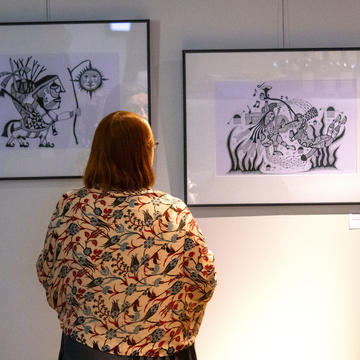 The back of a woman looking at artworks