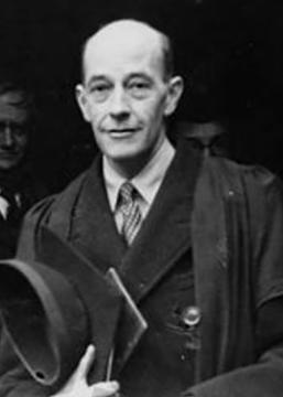 G. R. G. Mure in graduation regalia looking into the camera