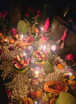 Fruits carved elaborately among candles and greenery like some sort of altar