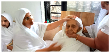 Women in white attire tending to a deceased individual