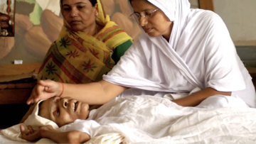 Nun attending to old woman