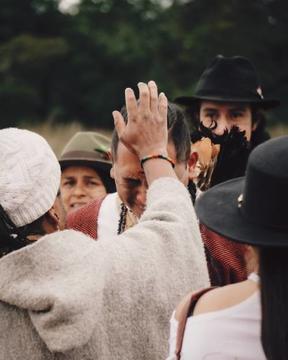 Man in white shirt touching another person's head in a large crowd