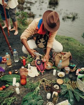 Man crouching on the ground over sacred plants 