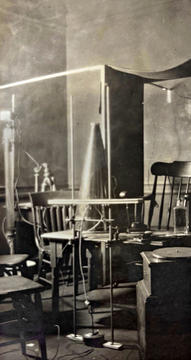 Black and white photo of laboratory with chairs, lights, screens and other apparatus