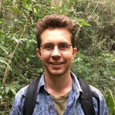 Photo of Alex Gearin smiling in the jungle