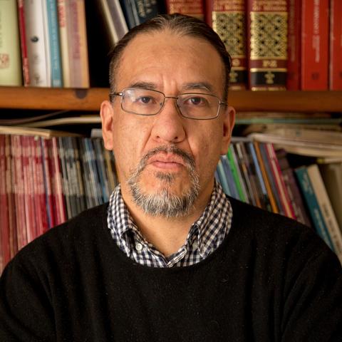 Headshot of scholar Osiris Gonzalez Romero in front of a bookshelf