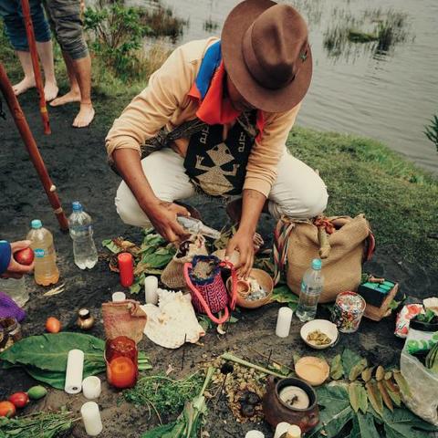 Man crouching on the ground over sacred plants 