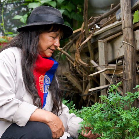 Woman knealing outside, near plants