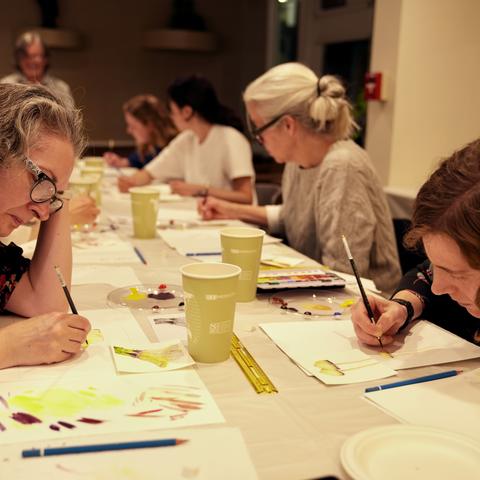 Table of students working on their paintings
