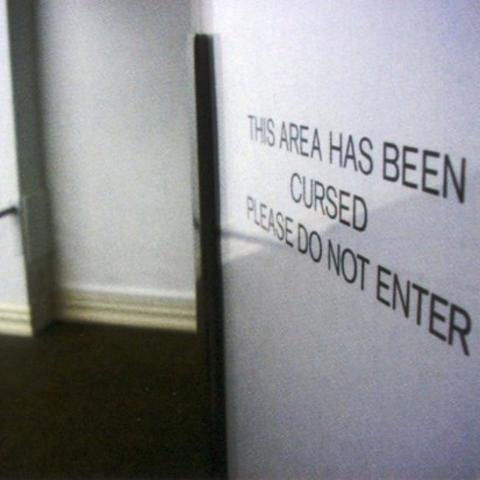 Photo of an entrance with sign stating that the area has been cursed