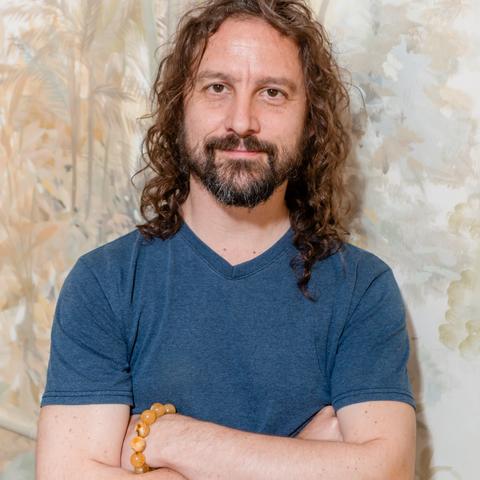 Simon Cox, arms crossed, smiling into the camera