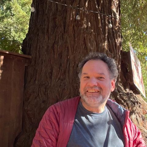 Dan Wells smiling in front of a tree