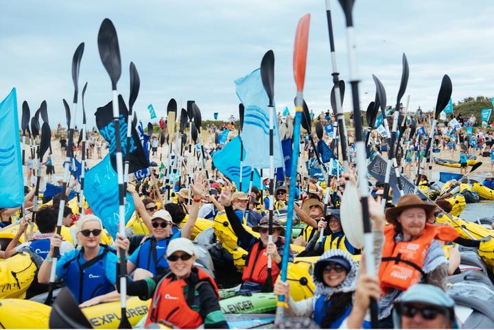 Activists holding up their kayak paddles with Rising Tide Australia
