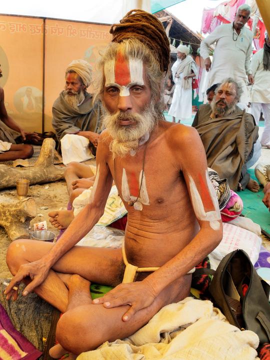 Sadhu seated among others looking at the camera