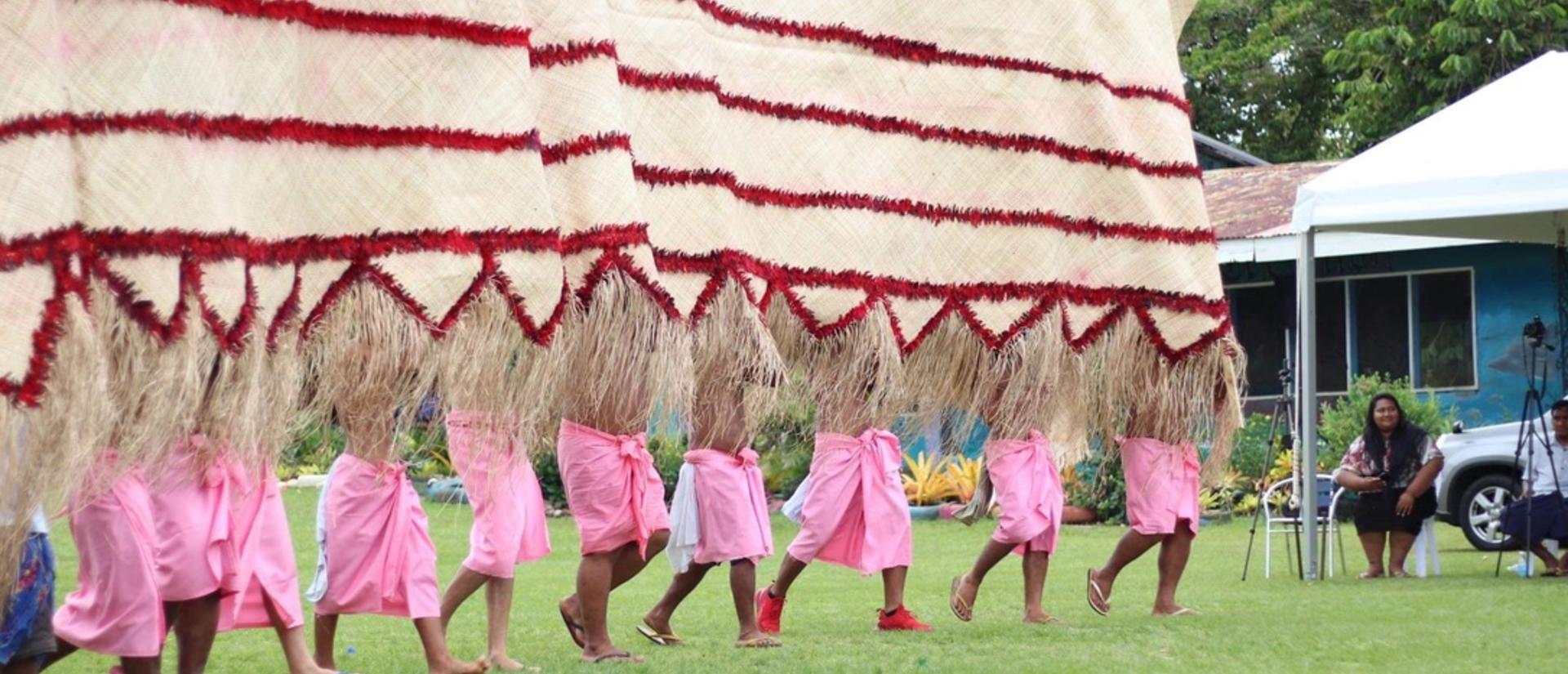 Samoan indigenous people carrying large fabric banner