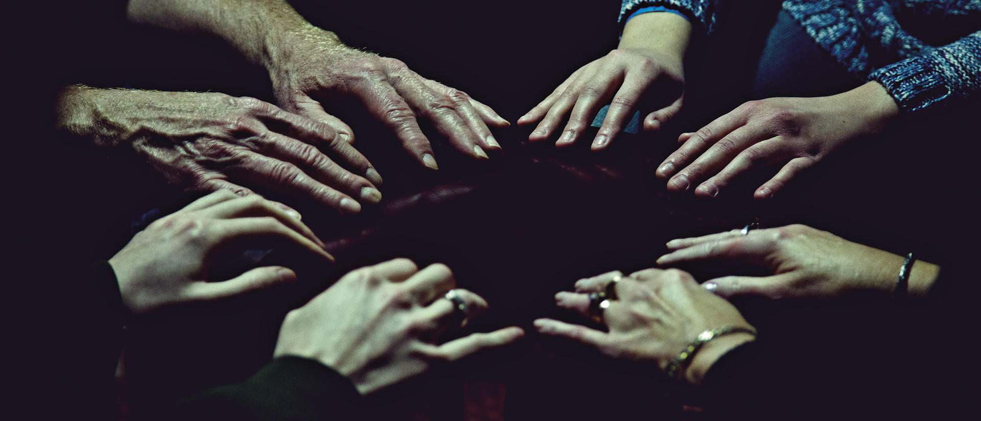 Four hands flat on a table in a circle