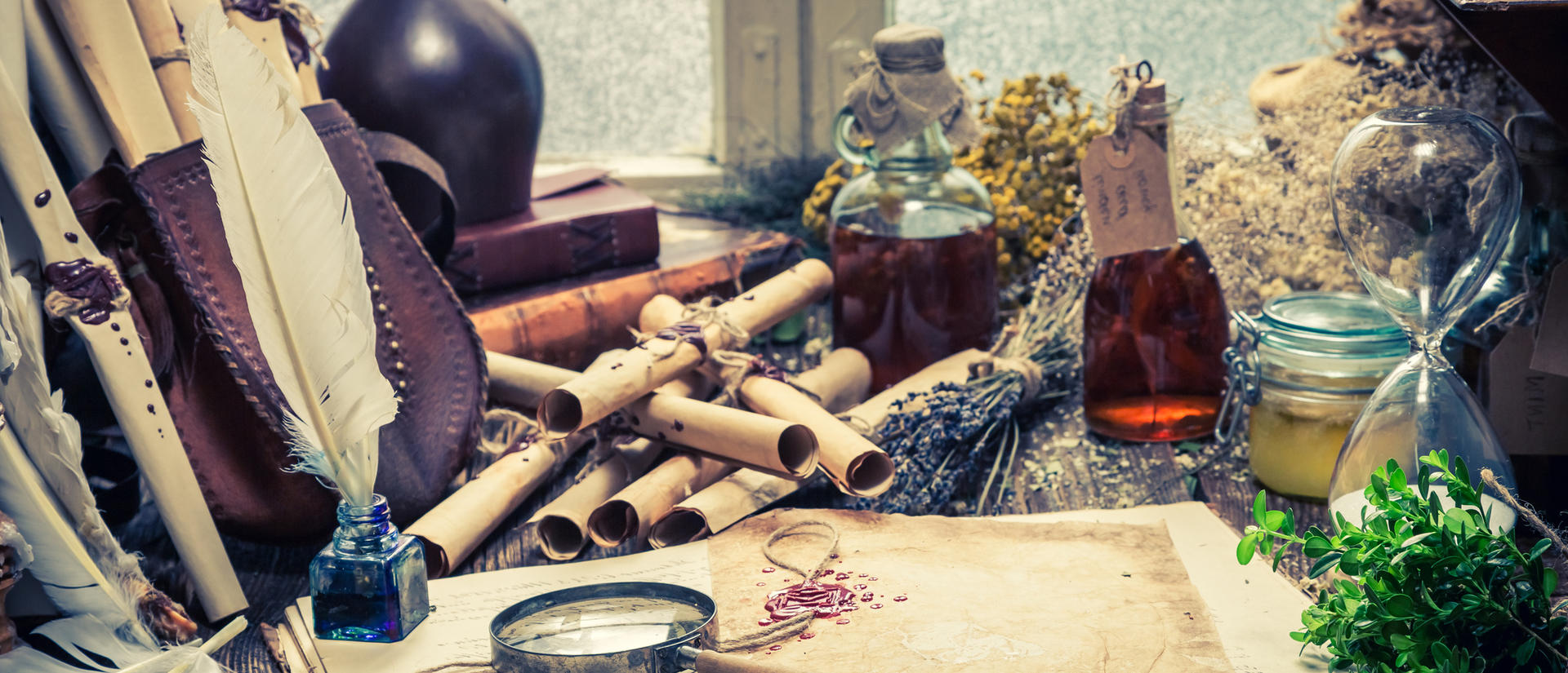 Lab desk with magnifying glass, scrolls, plant specimens, and tinctures