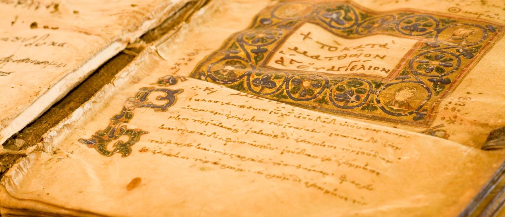 Ancient codex laying open on wooden table