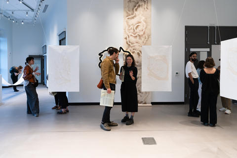 Two people discuss art exhibition 