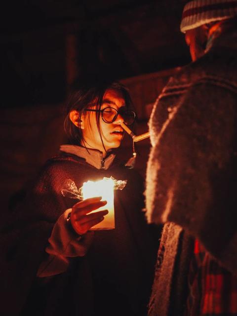 Woman holding a candle at night during a spiritual ceremony