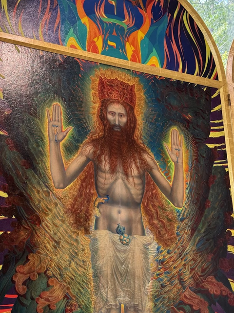 Photo of a painting of Jesus Christ with arms outstretched. 