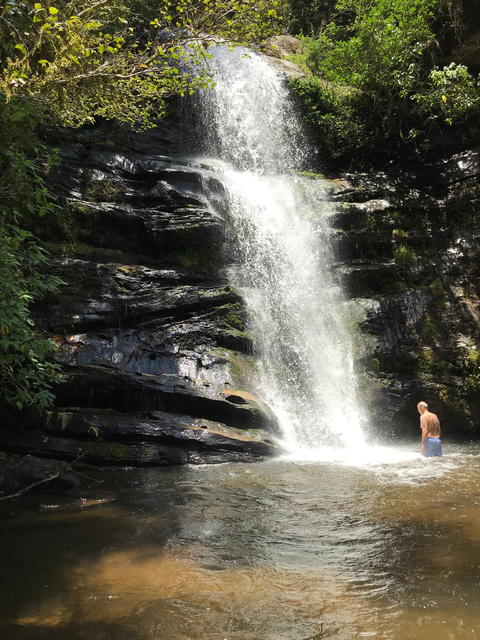 man standing at a waterfall