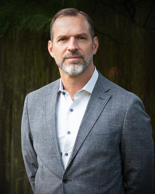 Professor Charles Stang in a dress shirt and gray blazer