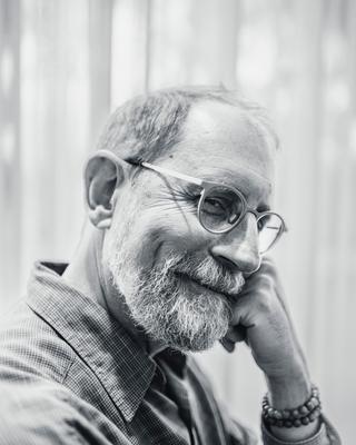 Erik Davis, check on fist, smiling sideways into the camera