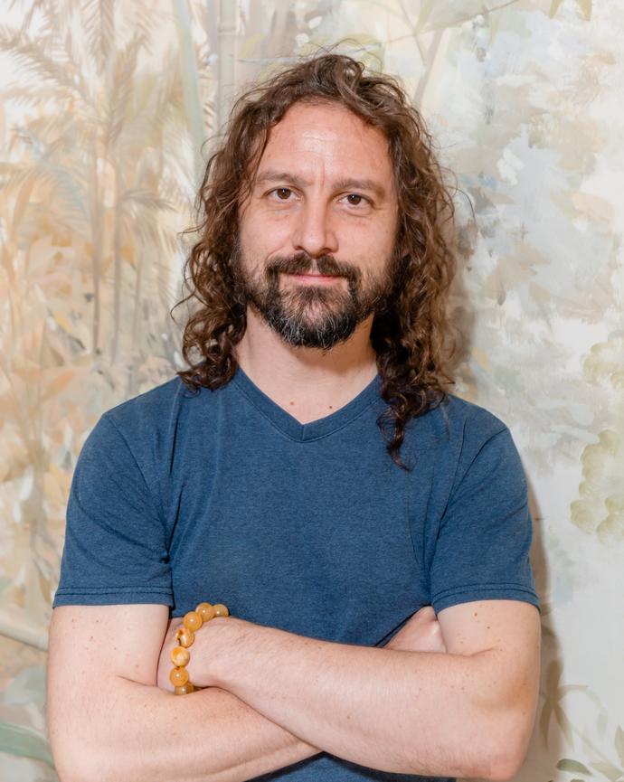 Simon Cox, arms crossed, smiling into the camera