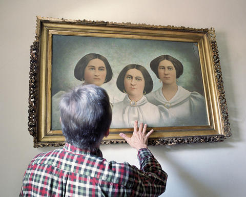 Person reaching towards a painting of three women